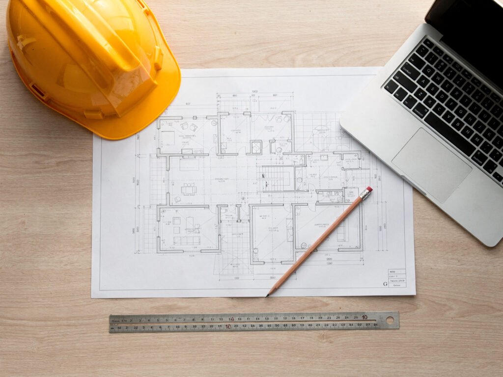Blueprints with a yellow hard hat (illustrative)